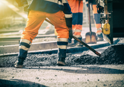 A worker shoveling gravel