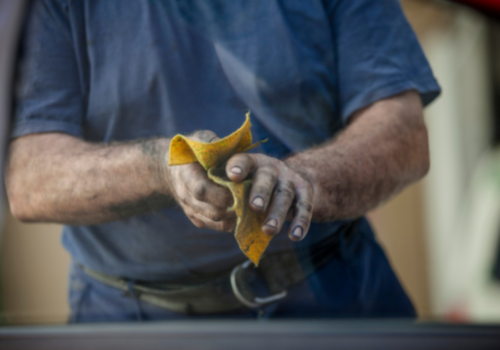A close up shot of a worker wiping off his hands with a towel