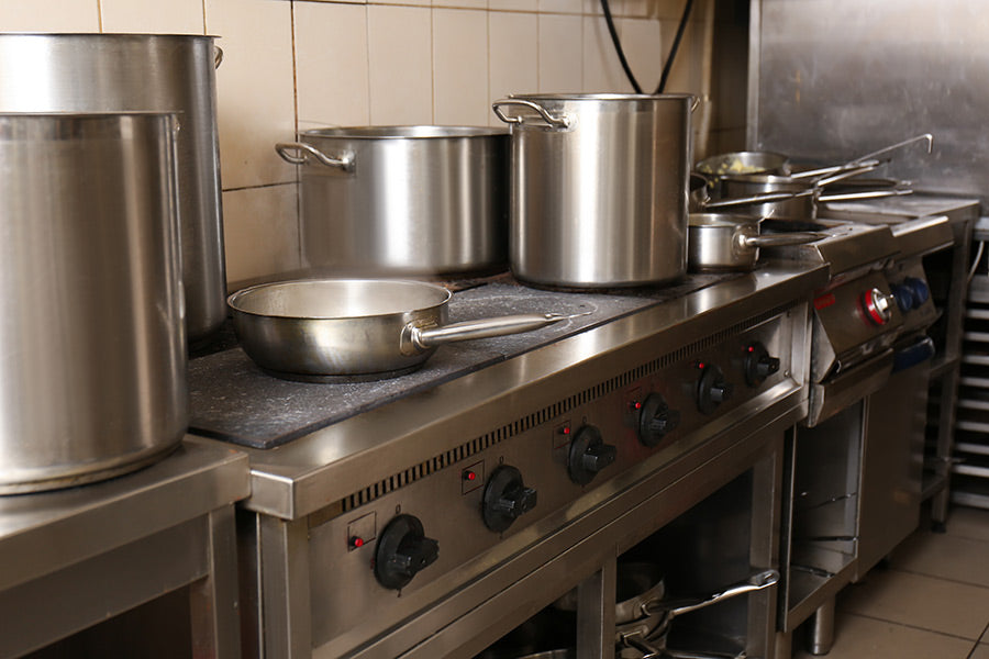 A stove and stove top in a professional commercial kitchen